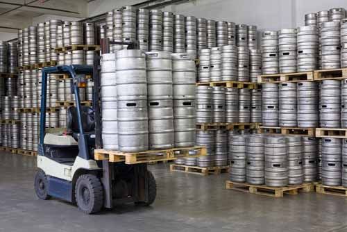 Barrels of beer are stored in a warehouse